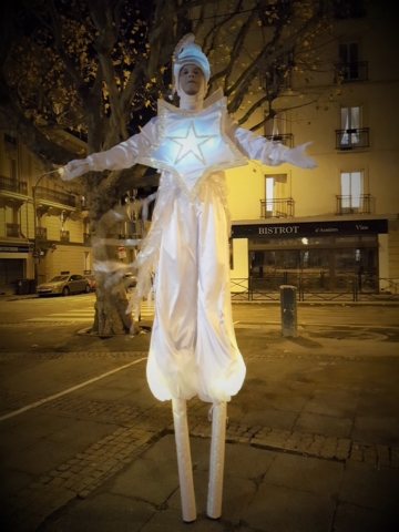 spectacle de rue avec echassier blanc lumineux