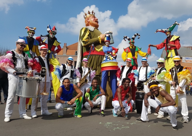spectacle deambulatoire coloré avec acrobate musiciens et echassier